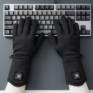 A woman wearing SAVIOR thin heated gloves is working in front of a computer